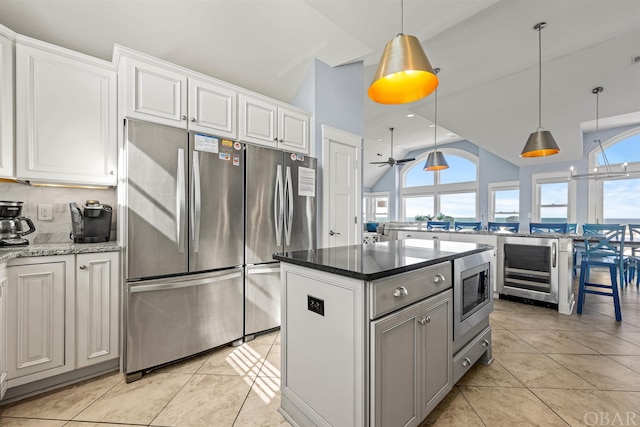 kitchen with hanging light fixtures, white cabinetry, and dark stone counters