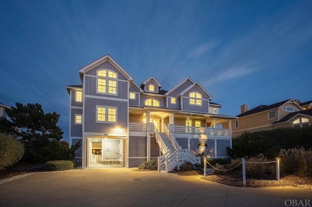 view of front facade with covered porch, driveway, stairway, and board and batten siding