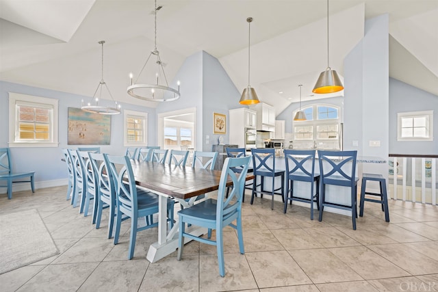 dining space with an inviting chandelier, plenty of natural light, and high vaulted ceiling