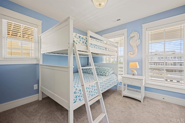 carpeted bedroom featuring visible vents and baseboards