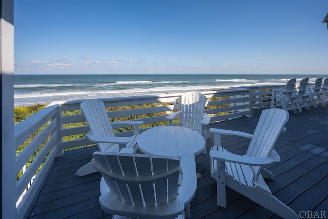 wooden terrace with a water view and a view of the beach