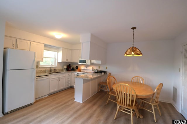 1006 Swordfish Way Unit 1006, Kitty Hawk, NC 27949 - kitchen with white appliances, a peninsula, a sink, white cabinets, and light wood finished floors