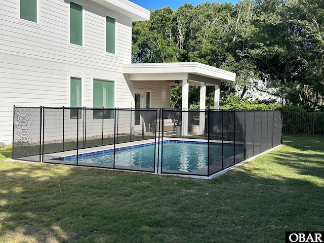 view of pool featuring a lawn, fence, and a fenced in pool