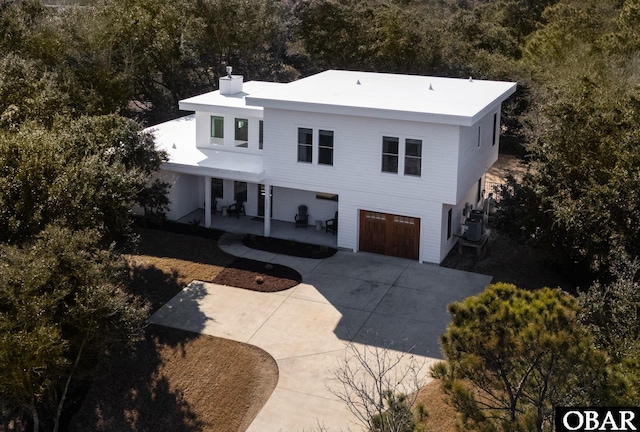 view of front of home featuring an attached garage, central AC unit, and concrete driveway