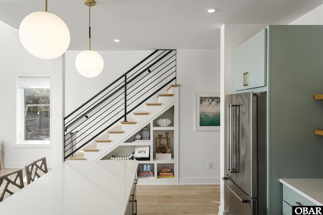 stairway with recessed lighting, baseboards, and wood finished floors