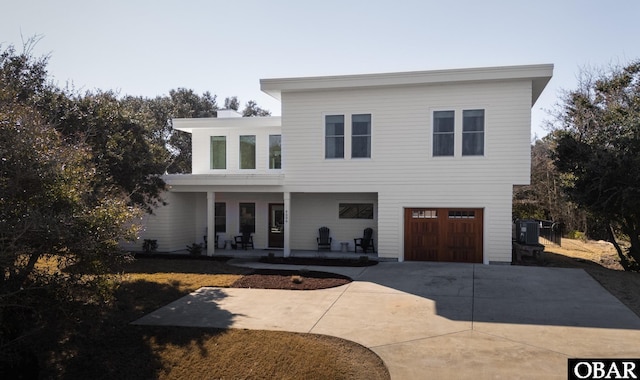 view of front of house with a garage, covered porch, driveway, and central AC unit