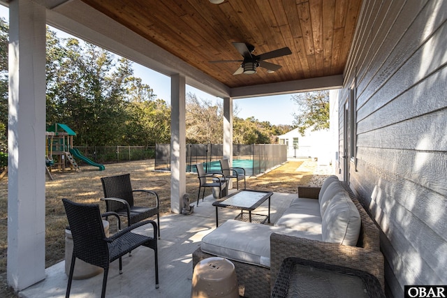 view of patio / terrace featuring ceiling fan, a playground, a fenced backyard, and an outdoor living space