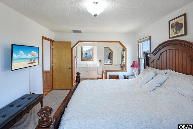 carpeted bedroom featuring a wainscoted wall