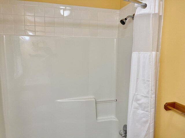 bathroom with shower / bathtub combination with curtain and a textured ceiling