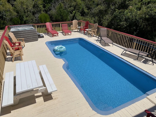 outdoor pool with a deck, a patio, and a jacuzzi