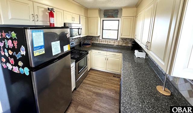 kitchen with dark countertops, stainless steel appliances, tasteful backsplash, and a textured ceiling