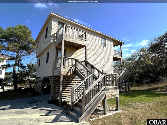 back of property featuring stairs and a balcony