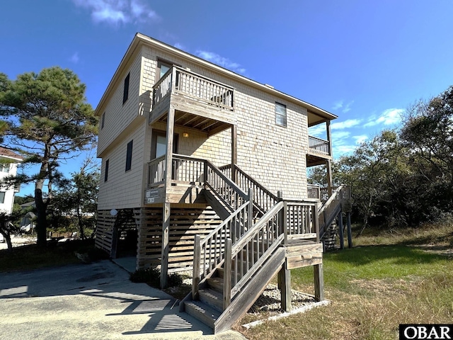 rear view of house featuring stairs and a balcony