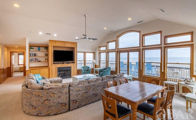 living area with high vaulted ceiling, recessed lighting, light colored carpet, and a fireplace