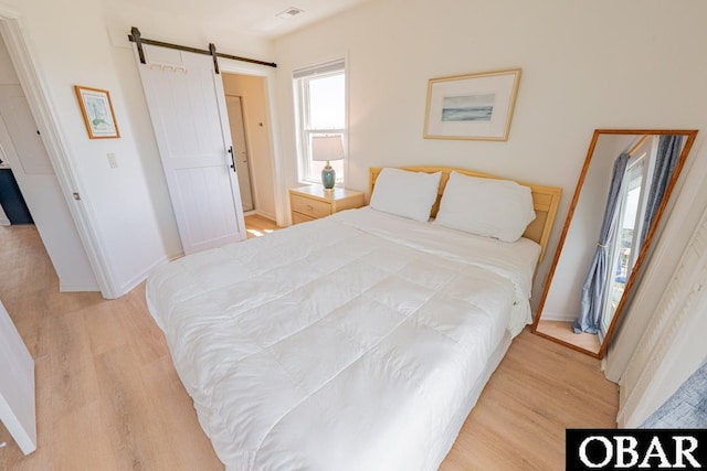 804 S Memorial Blvd Unit 3-D, Kill Devil Hills, NC 27948 - bedroom with a barn door, light wood-style flooring, and baseboards