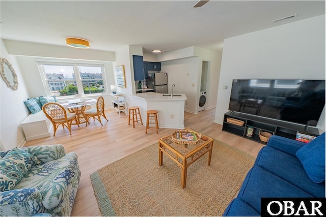 804 S Memorial Blvd Unit 3-D, Kill Devil Hills, NC 27948 - living area featuring washer / clothes dryer, light wood-type flooring, and baseboards