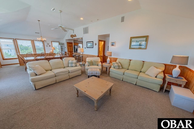 living area with ceiling fan with notable chandelier, visible vents, carpet floors, and high vaulted ceiling