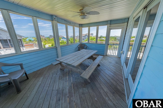 unfurnished sunroom featuring ceiling fan