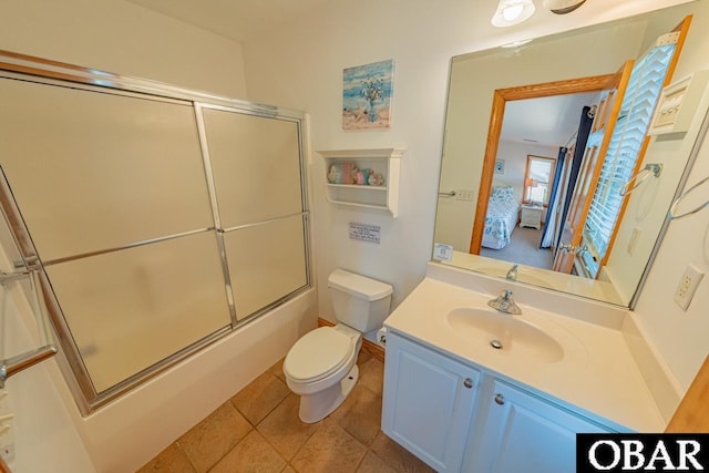 ensuite bathroom featuring tile patterned floors, toilet, combined bath / shower with glass door, connected bathroom, and vanity