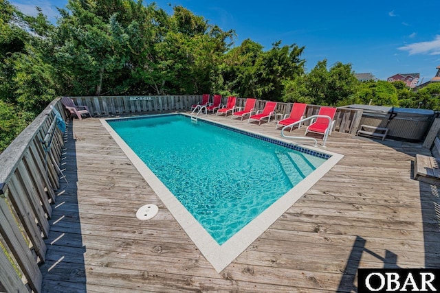 view of swimming pool with a fenced in pool, a hot tub, a deck, and fence