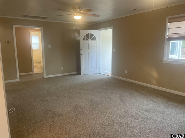 unfurnished bedroom with baseboards, visible vents, crown molding, and carpet flooring