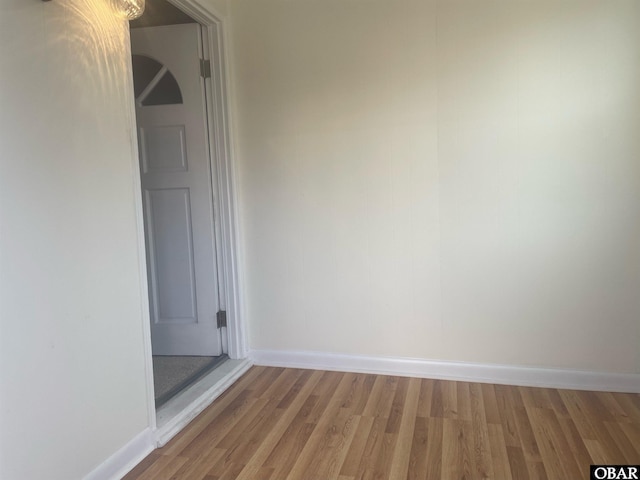 unfurnished room featuring wood finished floors and baseboards