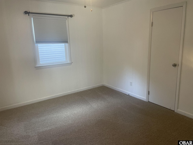 carpeted spare room featuring baseboards