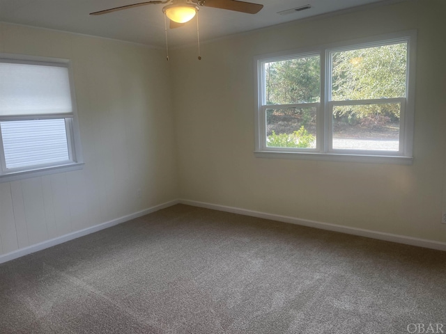 carpeted spare room with ceiling fan, visible vents, and baseboards