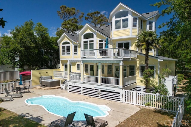 rear view of house featuring a fenced in pool, a patio area, fence, a balcony, and a jacuzzi