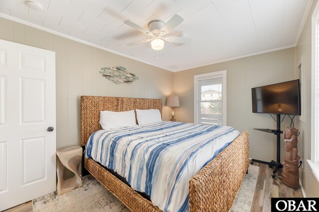 bedroom featuring wood finished floors, a ceiling fan, and ornamental molding