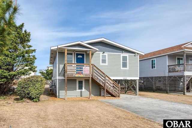 view of front of home featuring a carport, stairway, and driveway