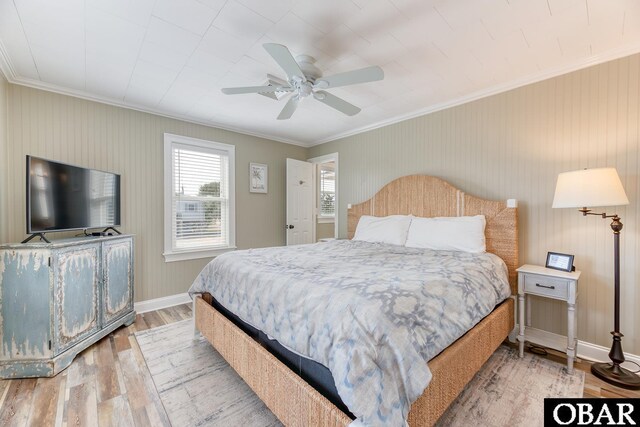 bedroom with baseboards, a ceiling fan, wood finished floors, and crown molding