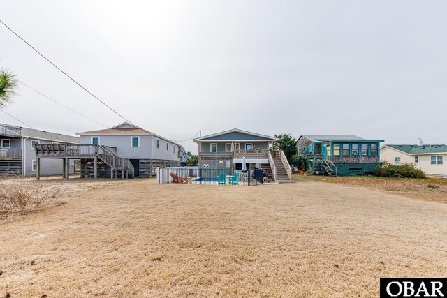 back of house featuring stairway, a wooden deck, and fence