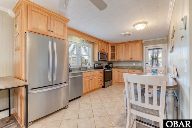 kitchen with ornamental molding, light brown cabinetry, a sink, plenty of natural light, and stainless steel appliances