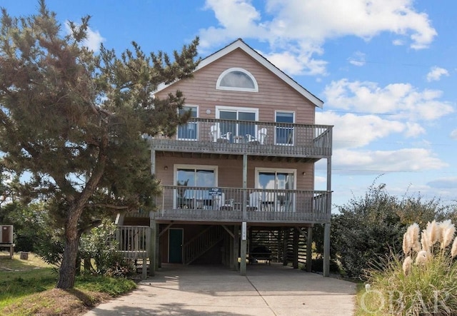 view of front of property with driveway, a carport, a porch, and a balcony