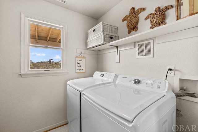 laundry area with laundry area, baseboards, visible vents, and washer and dryer