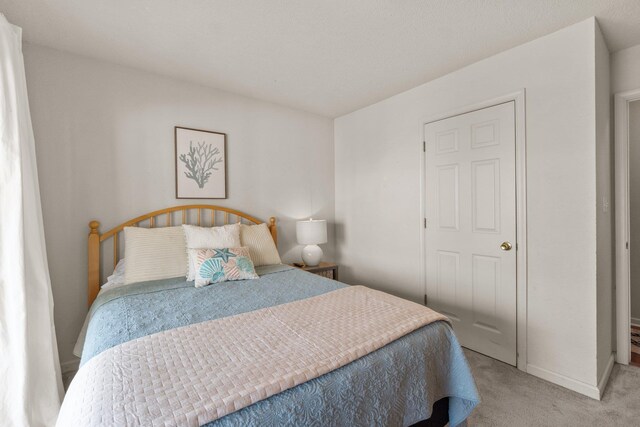 bedroom with baseboards and light colored carpet