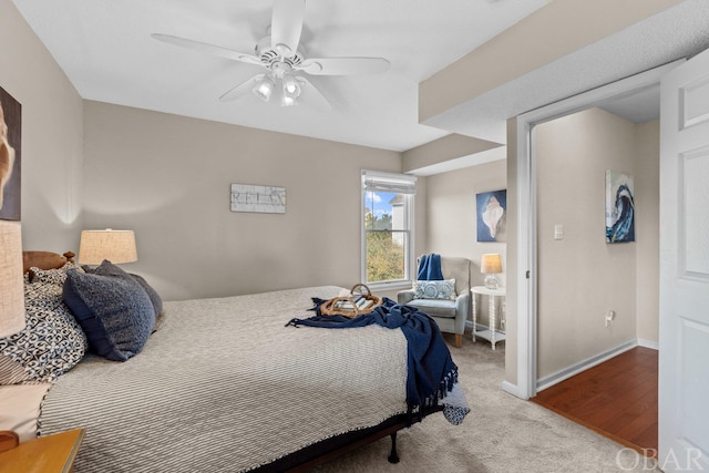 bedroom featuring light carpet, ceiling fan, and baseboards