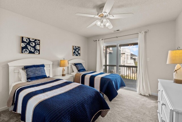 bedroom featuring access to exterior, light colored carpet, visible vents, and a textured ceiling