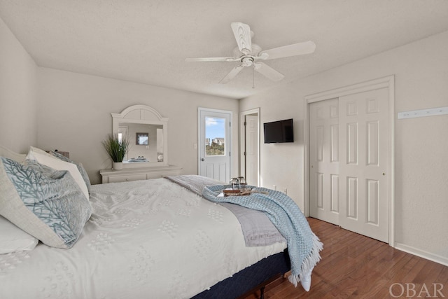 bedroom with a ceiling fan, a closet, dark wood finished floors, and baseboards