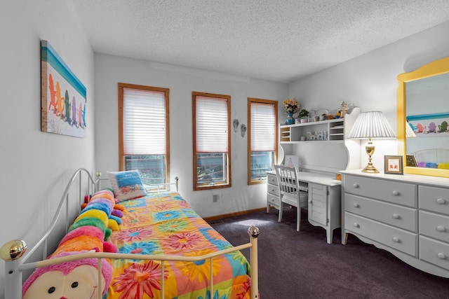 bedroom with a textured ceiling, dark carpet, and baseboards