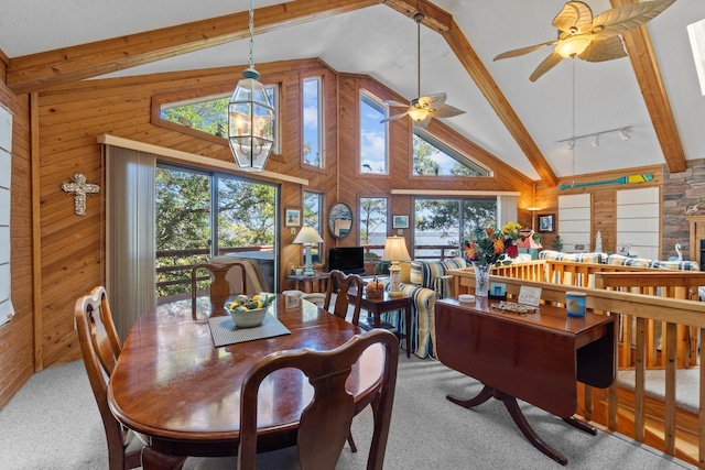 dining space with light carpet, a chandelier, wood walls, high vaulted ceiling, and beam ceiling