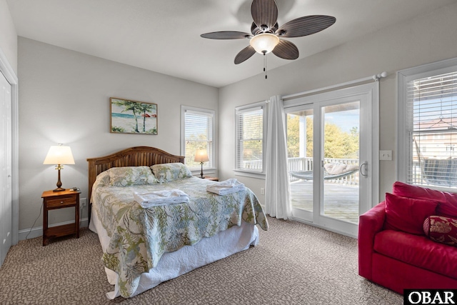 carpeted bedroom with access to outside, baseboards, multiple windows, and a ceiling fan