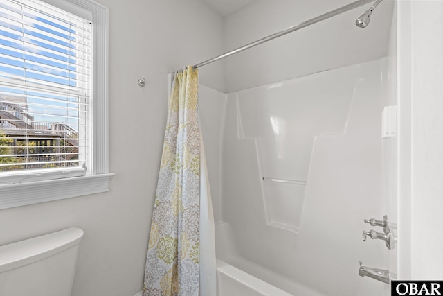 bathroom with toilet and shower / bath combo with shower curtain