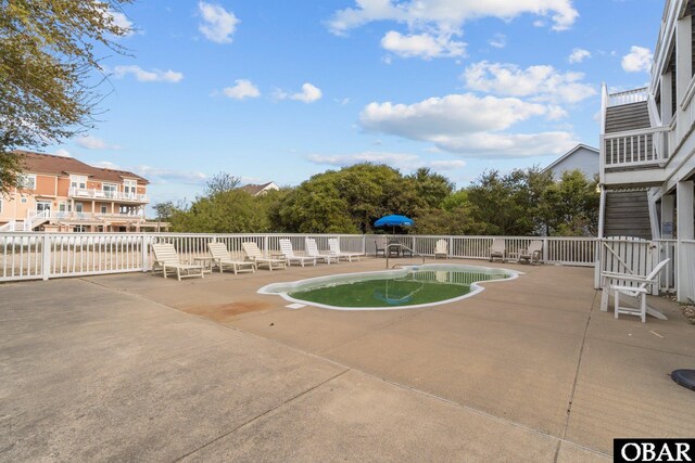 view of swimming pool featuring a patio, fence, and a fenced in pool