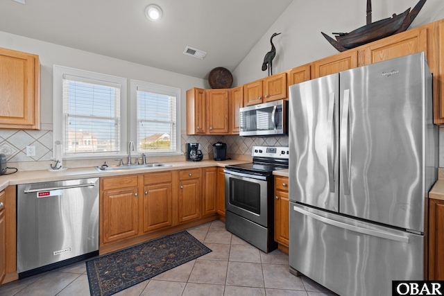 kitchen with visible vents, a sink, light countertops, lofted ceiling, and stainless steel appliances