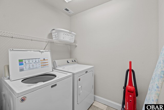washroom with laundry area, washer and clothes dryer, baseboards, and visible vents