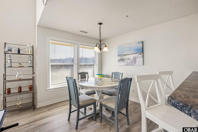 1700 Paget Rd Unit B3, Kill Devil Hills, NC 27948 - dining area with a chandelier, light wood-style floors, baseboards, and healthy amount of natural light