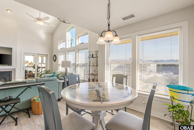 1700 Paget Rd Unit B3, Kill Devil Hills, NC 27948 - dining area with light wood-style flooring, a ceiling fan, a tile fireplace, baseboards, and high vaulted ceiling