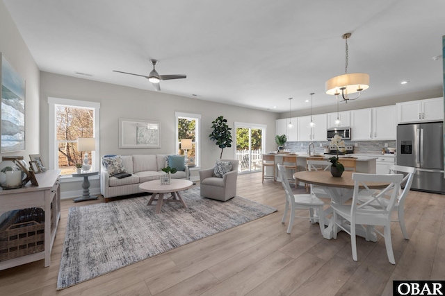 living room with recessed lighting, light wood-style flooring, visible vents, and ceiling fan